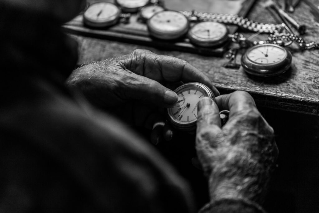 grayscale photo of person holding pocket watch